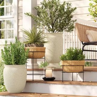 A tall white sculptural planter on an outdoor staircase