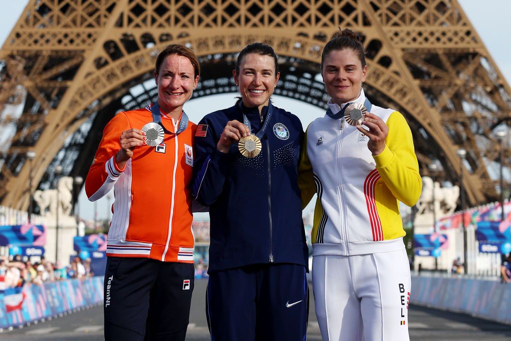 PARIS FRANCE AUGUST 04 Gold medalist Kristen Faulkner of Team United States C Silver medalist Marianne Vos of Team Netherlands L and Bronze medalist Lotte Kopecky of Team Belgium R pose on the podium with the Eiffel Tower in the background during the Womens Road Race on day nine of the Olympic Games Paris 2024 at Trocadero on August 04 2024 in Paris France Photo by Alex BroadwayGetty Images