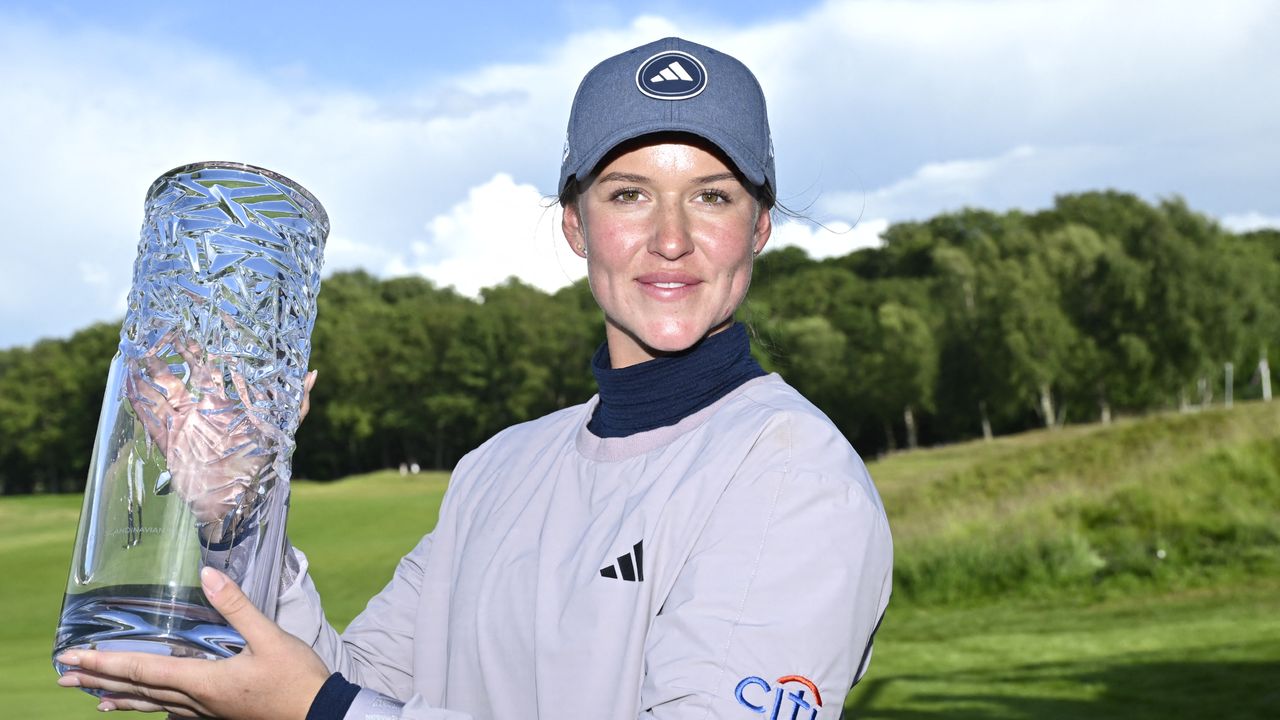 Linn Grant poses for a photograph with the Scandinavian Mixed trophy