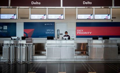 A Delta airlines employee waits for passengers in Ronald Reagan Washington National Airport in Arlington, Virginia, on May 12, 2020