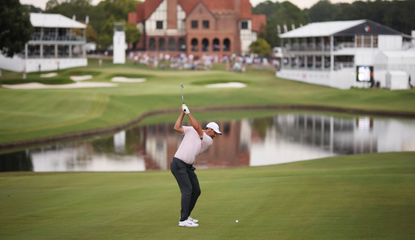 Scottie Scheffler hits an approach into the final hole at East Lake Golf Club