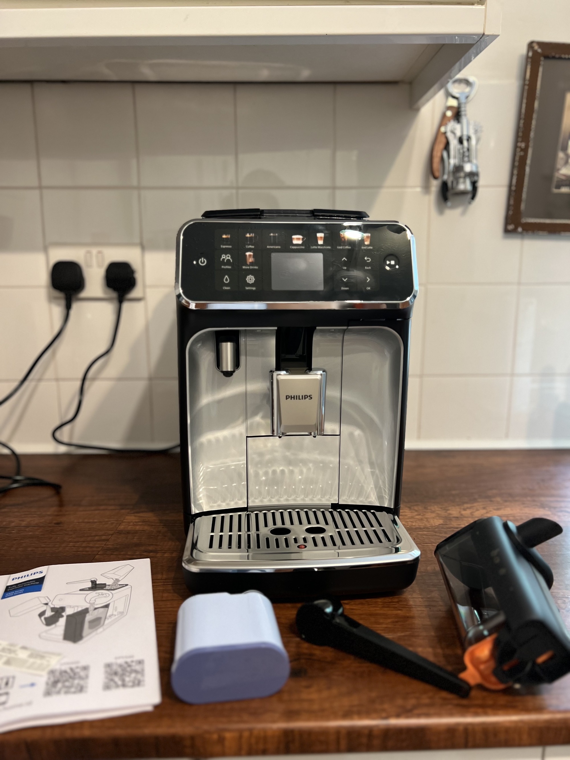 Image of a black and silver Philips Series 5500 machine on a wooden kitchen countertop.