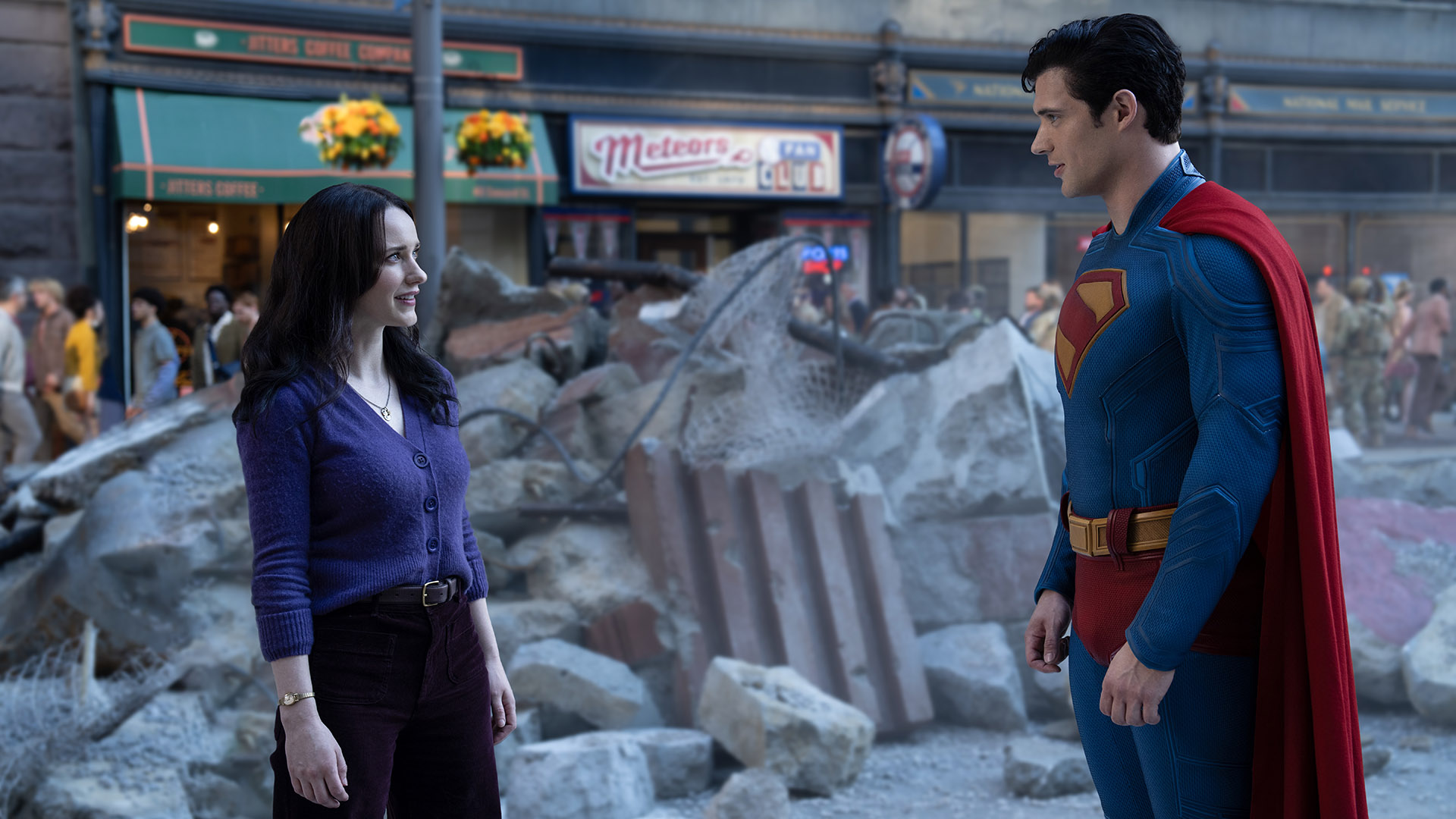 Lois Lane and Superman looking at each other on a street filled with rubble in 2025's Superman movie