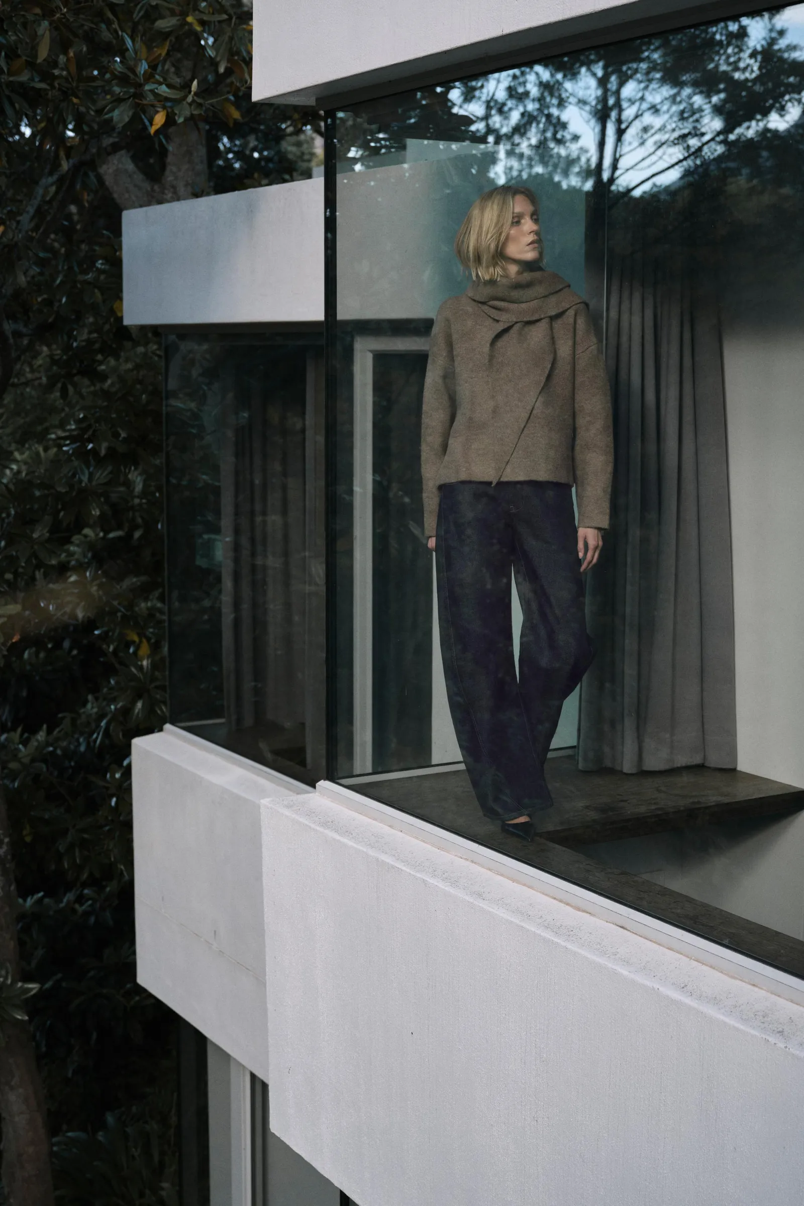 Woman wears scarf jumper, barrel leg jeans and heels