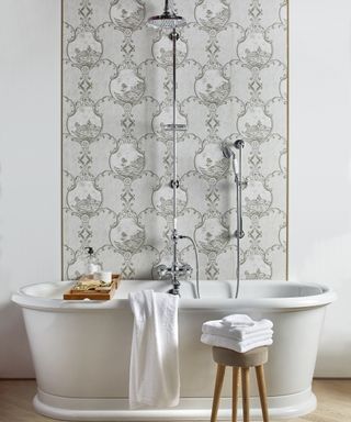 White wallpaper bathroom scheme with shower over bath by The Fine Cotton Company