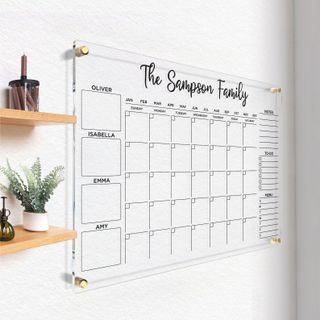 A large clear plastic wall-mounted family planner with note and to-do boxes.