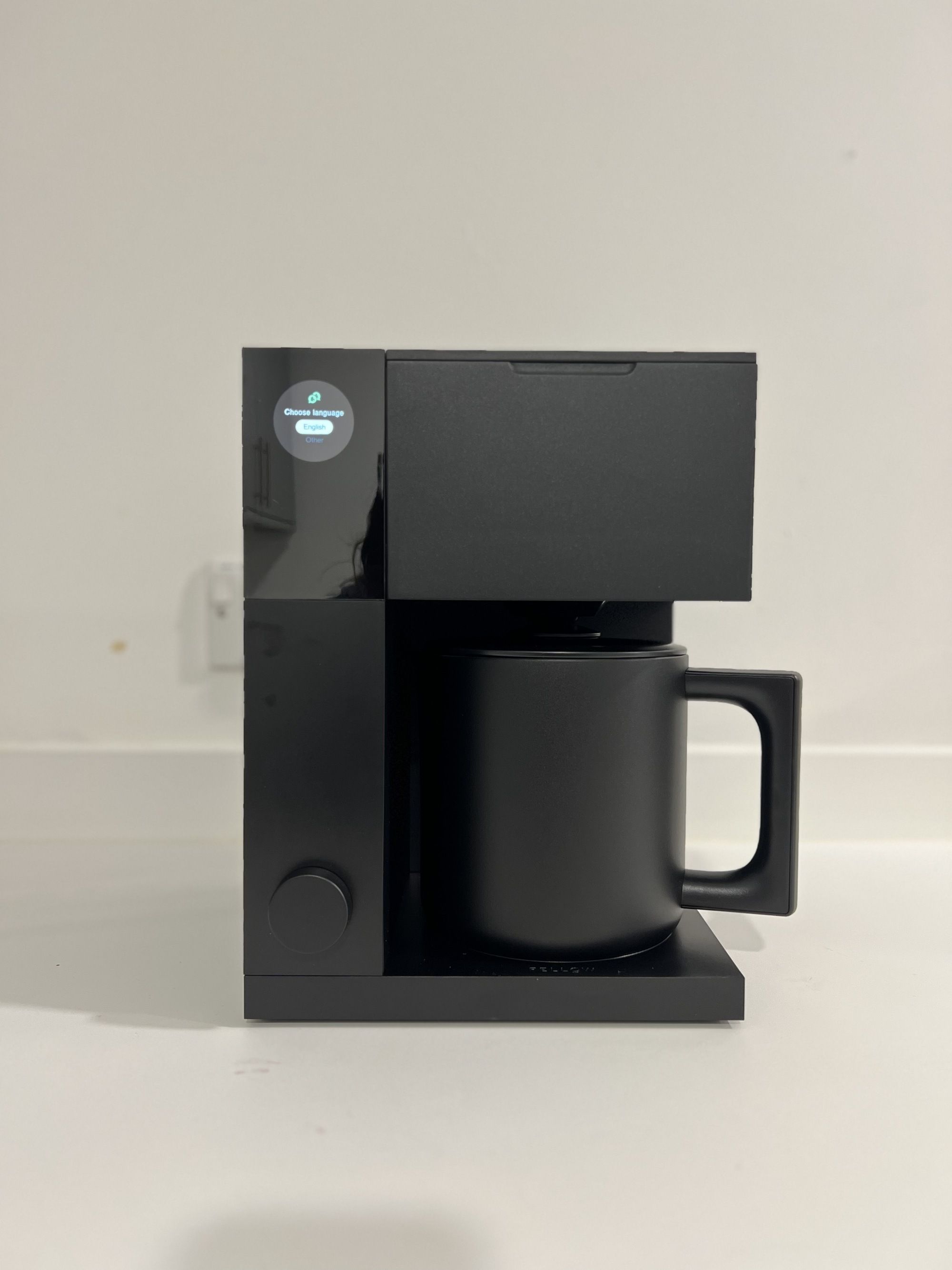 Image of the black Fellow Aiden Precision coffee maker in an all-white space.