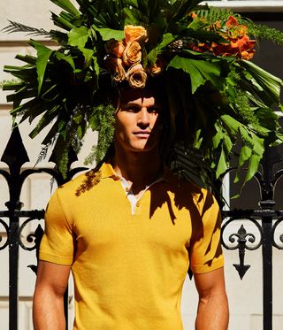 Man in yellow shirt wearing a large flower crown