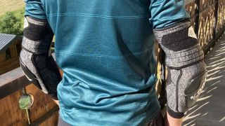 Rear view of man wearing two 100% Fortis Elbow Guards