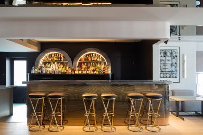 Renovated Groucho Club in London with arched shelving behind the bar