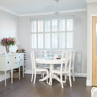 dining room with white wall and dining table with chair and wooden flooring