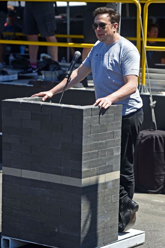 Elon Musk speaks from his lectern of bricks.