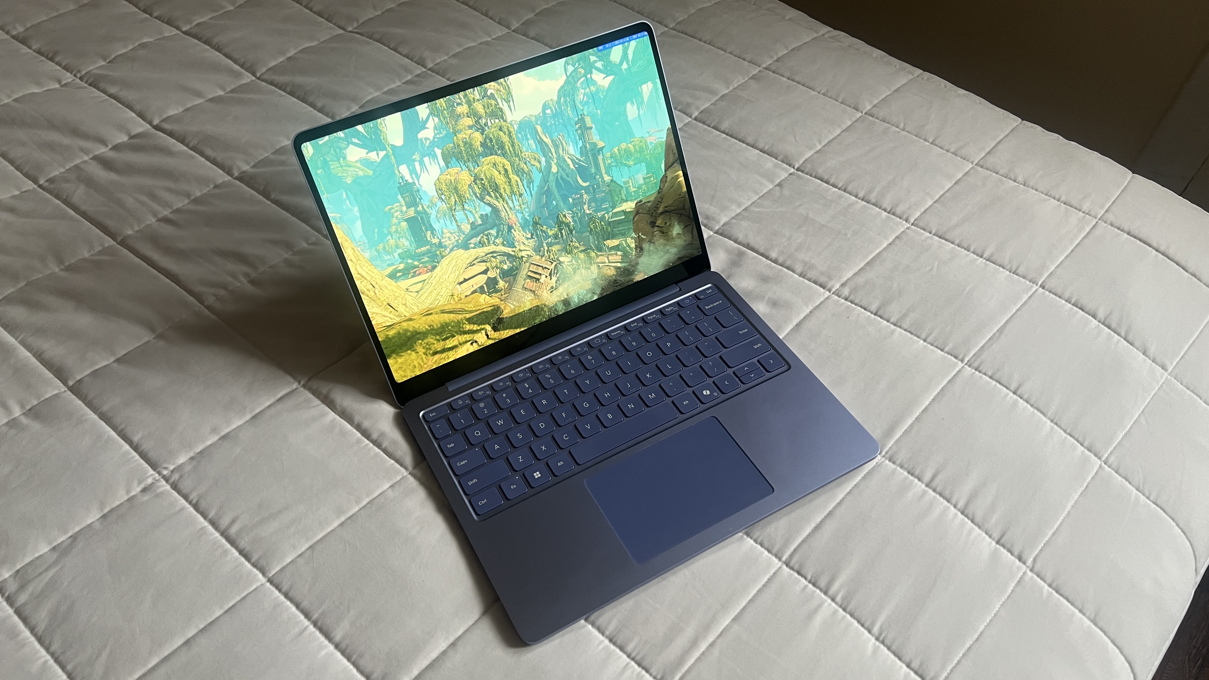 A Microsoft Surface Laptop 13-inch on a bed