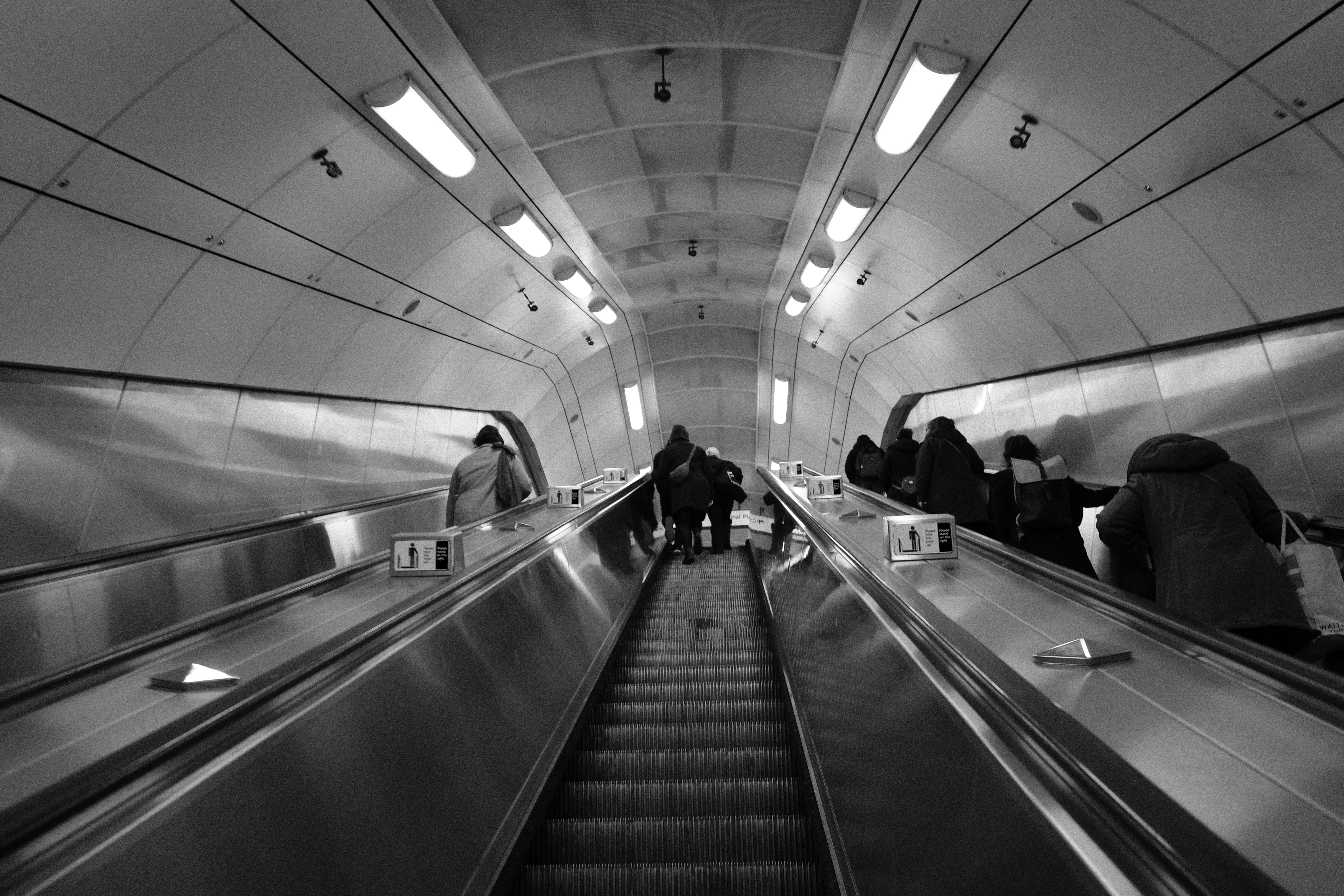 People riding up an escalator in the London Underground