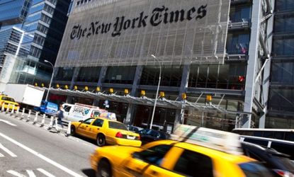 Traffic rushes past The New York Times headquarters in New York City.