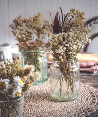 Stunning dried flower arrangements for your home. Dried flower bunches in empty jam jars.