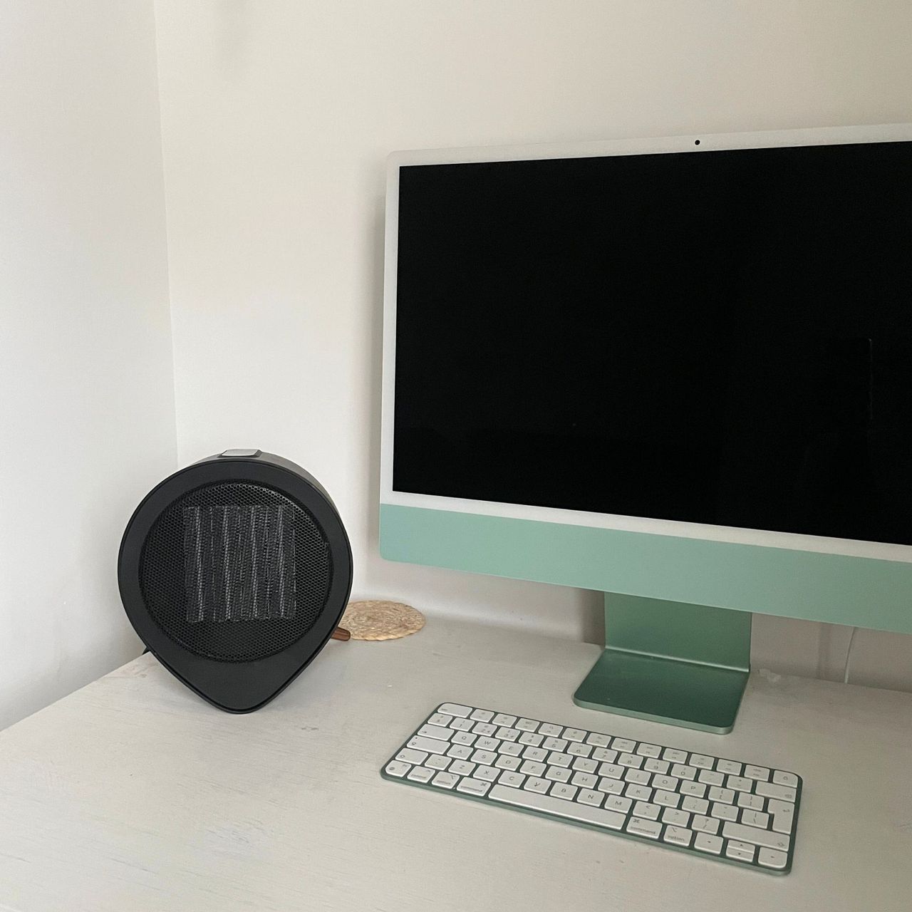 Russell Hobbs desktop heater sitting on a white desk next to a green iMac computer