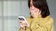 Woman looking shocked at something on her iPhone 17 Pro
