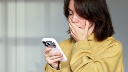 Woman looking shocked at something on her iPhone 17 Pro