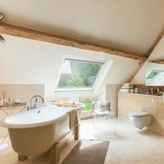 attic bathroom with bathtub and wooden beam