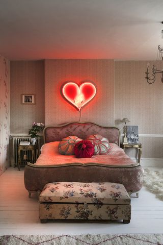 Pearl Lowe's bedroom with vintage furniture and neon heart light