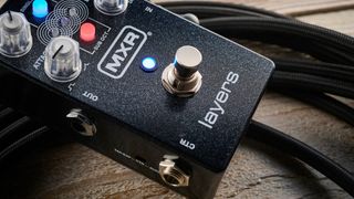 MXR Layers pedal in metallic black finish with clear controls pictured on wood floor with coiled guitar cable