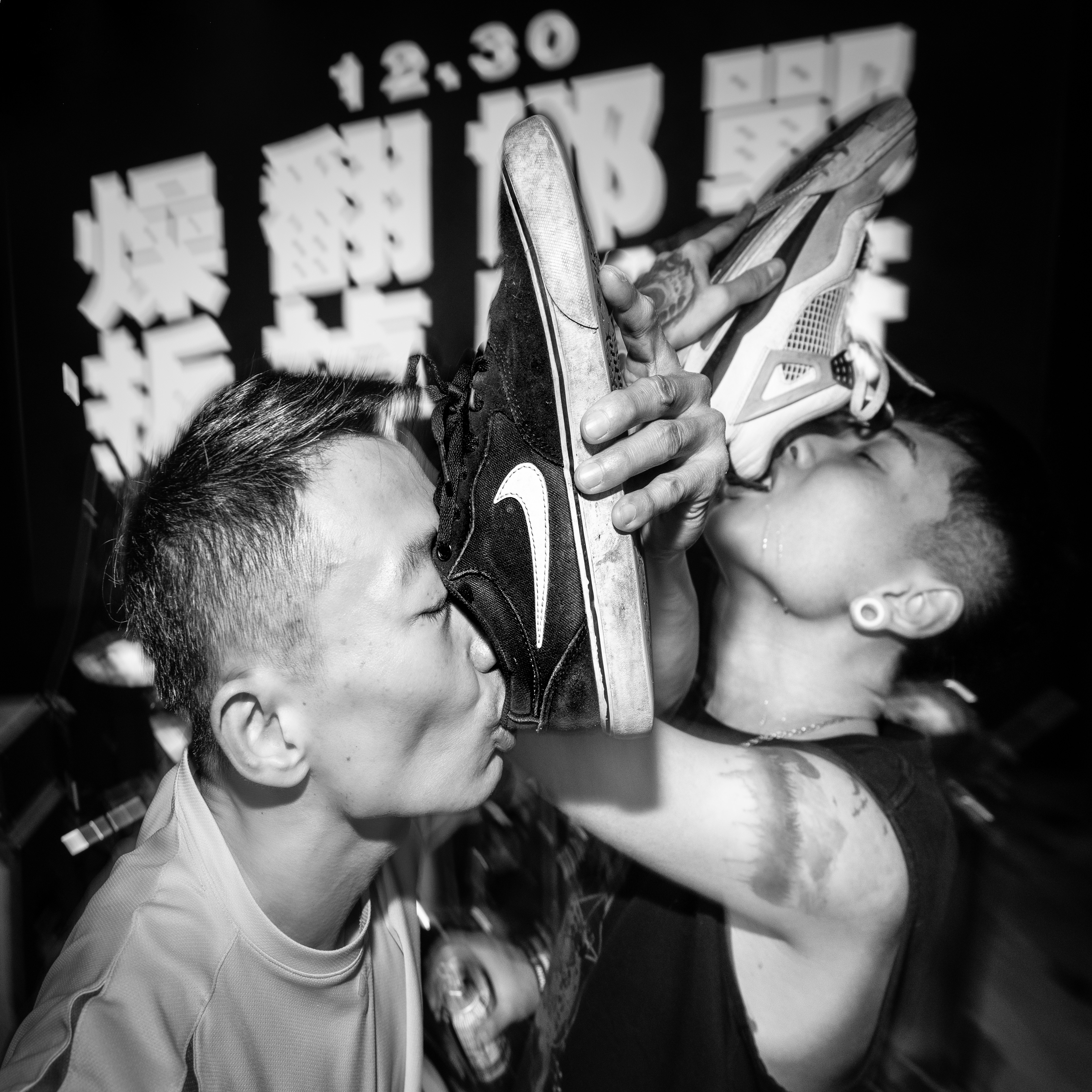 Two artists drink out of shoes at a music festival