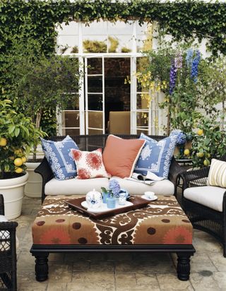 bohemian summer outdoor garden furniture with lots of colorful cushions with a plush ottoman