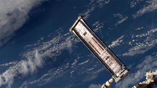 The Roll Out Solar Array (ROSA) experiment is seen deployed on the International Space Station at the end of the outpost's Canadarm 2 robotic arm on June 18, 2017. The flexible solar wing could be used to power future spacecraft.