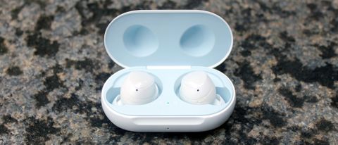 A pair of Samsung Galaxy Buds in white in their charging case on a grey surface