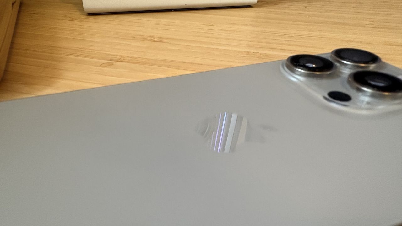 An iPhone 16 Pro on a wooden desk