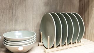 Plates inside a cupboard stacked in a divider