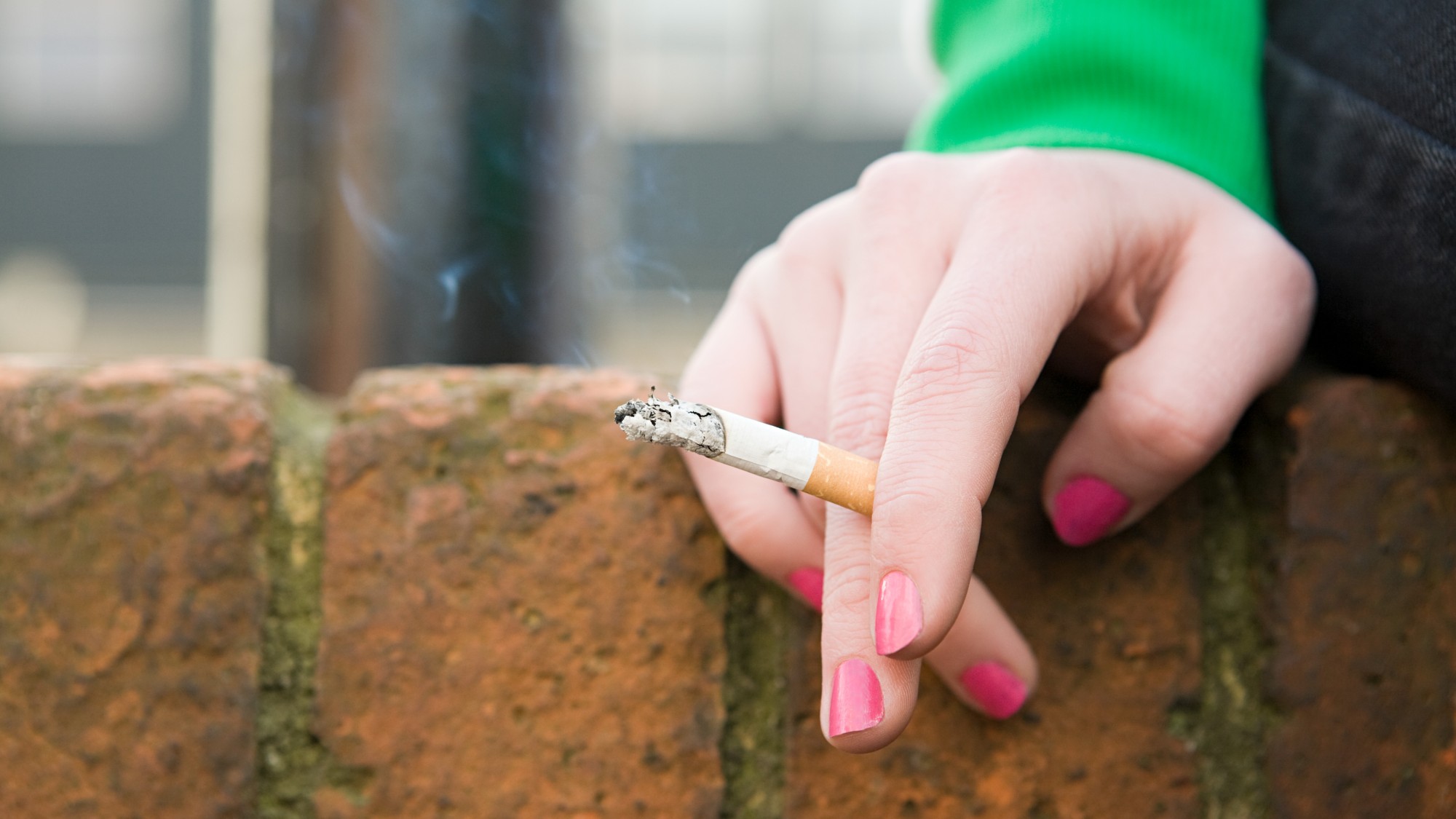 Close-up of a woman's hand holding a cigarette