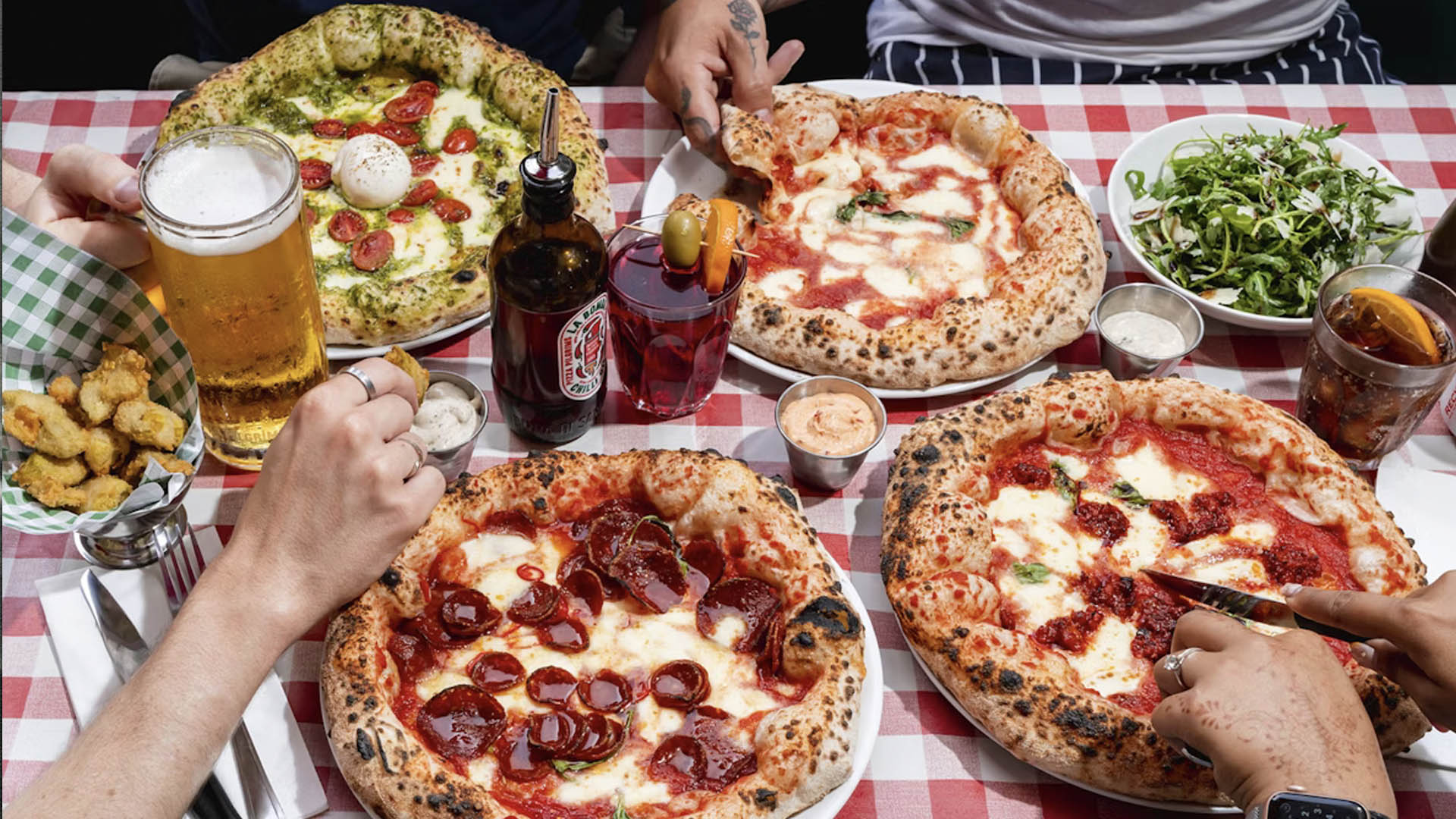 A photo of four pizzas from above. 