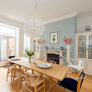 dinning room with blue wall dinning table with chairs and white doors