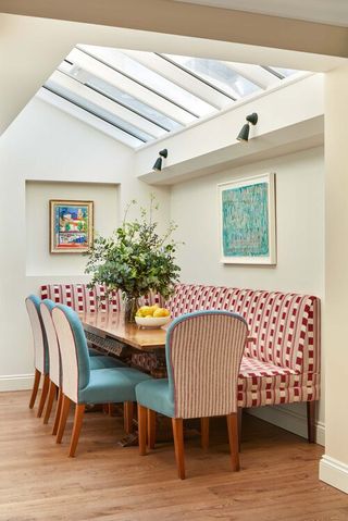 Dining table with banquette and dining chairs under skylights