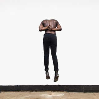 Moses Sumney's Aromanticism album cover shows a topless man from behind, floating and with his head down so it looks at first glance like it's missing