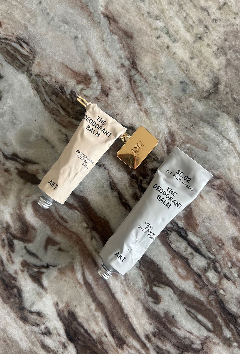 AKT The Deodorant Balm tubes in No Notes and After Thunder on marble surface