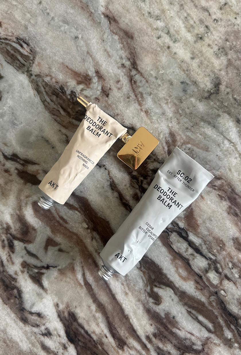 AKT The Deodorant Balm tubes in No Notes and After Thunder on marble surface