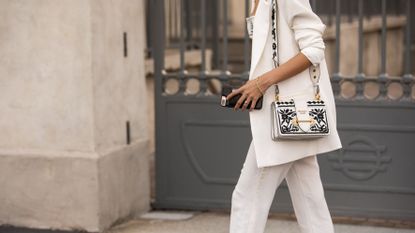 A woman wearing a white suit