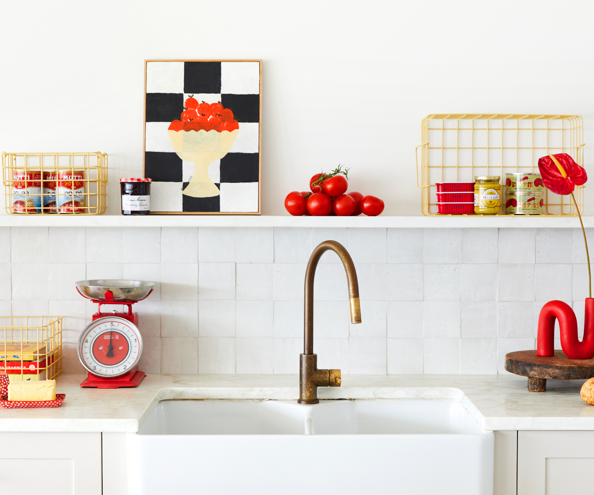 kitchen sink area in white with red and yellow accessories