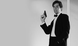 The Living Daylights Timothy Dalton poses with his gun, standing against a pole