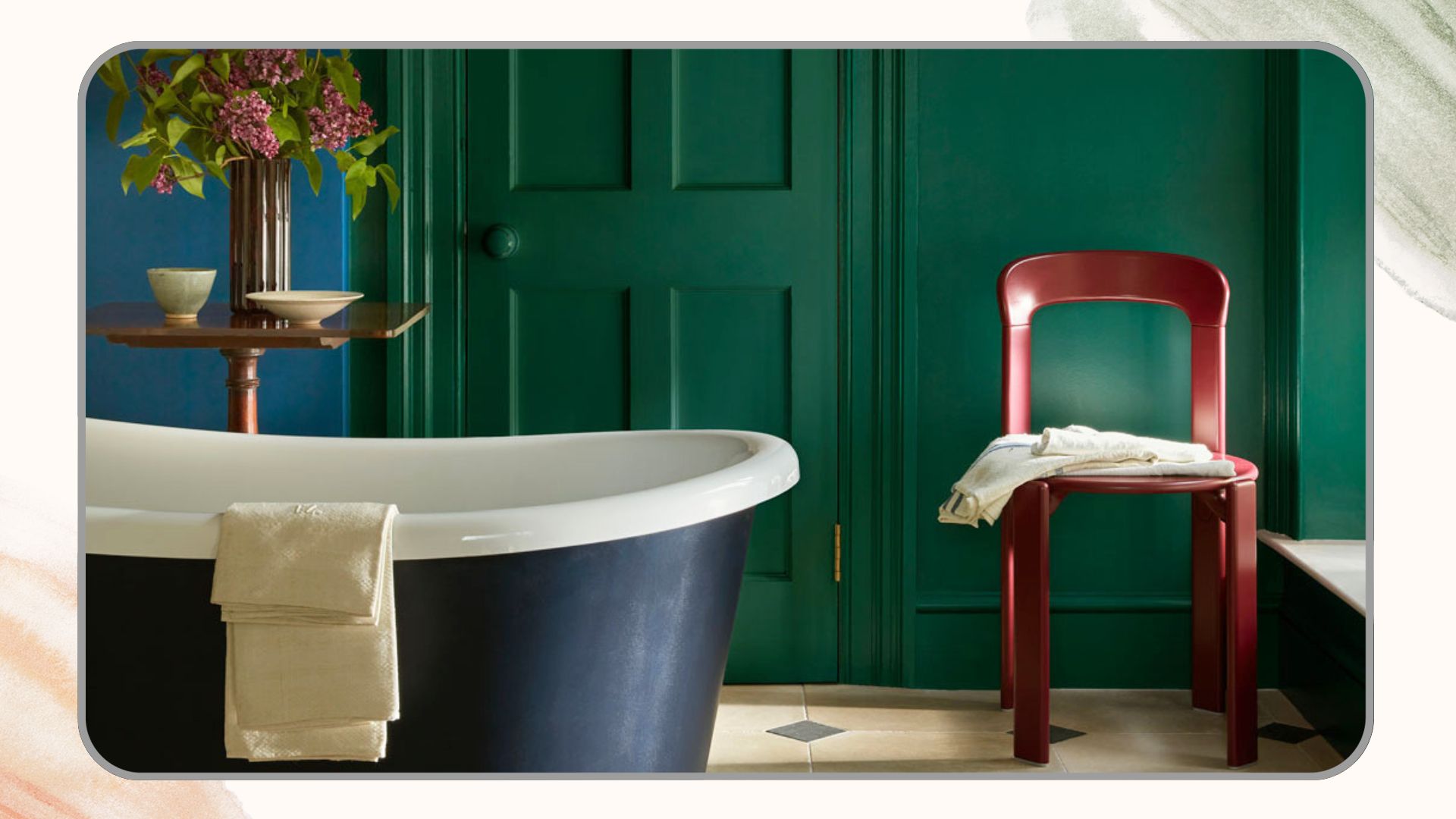green and blue small bathroom with a blue rolltop bath with a red chair in the corner