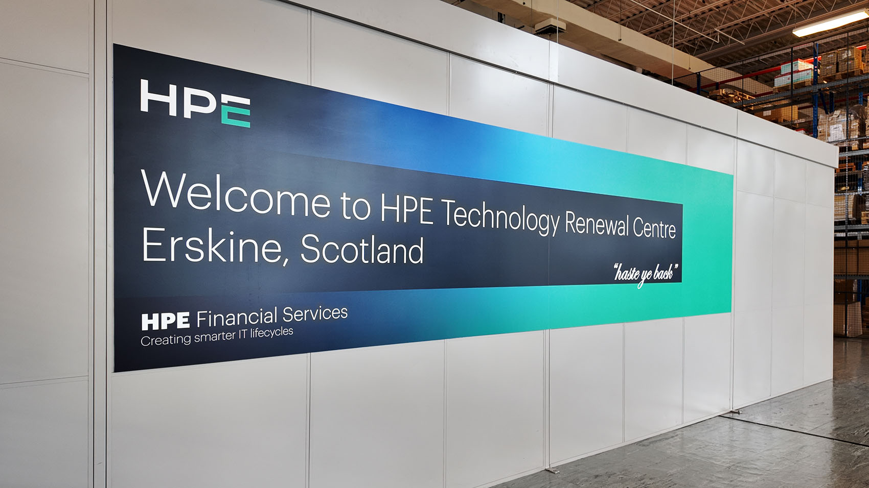 Large blue and teal sign welcoming visitors to HPE's technology renewal center in Erskine, Scotland