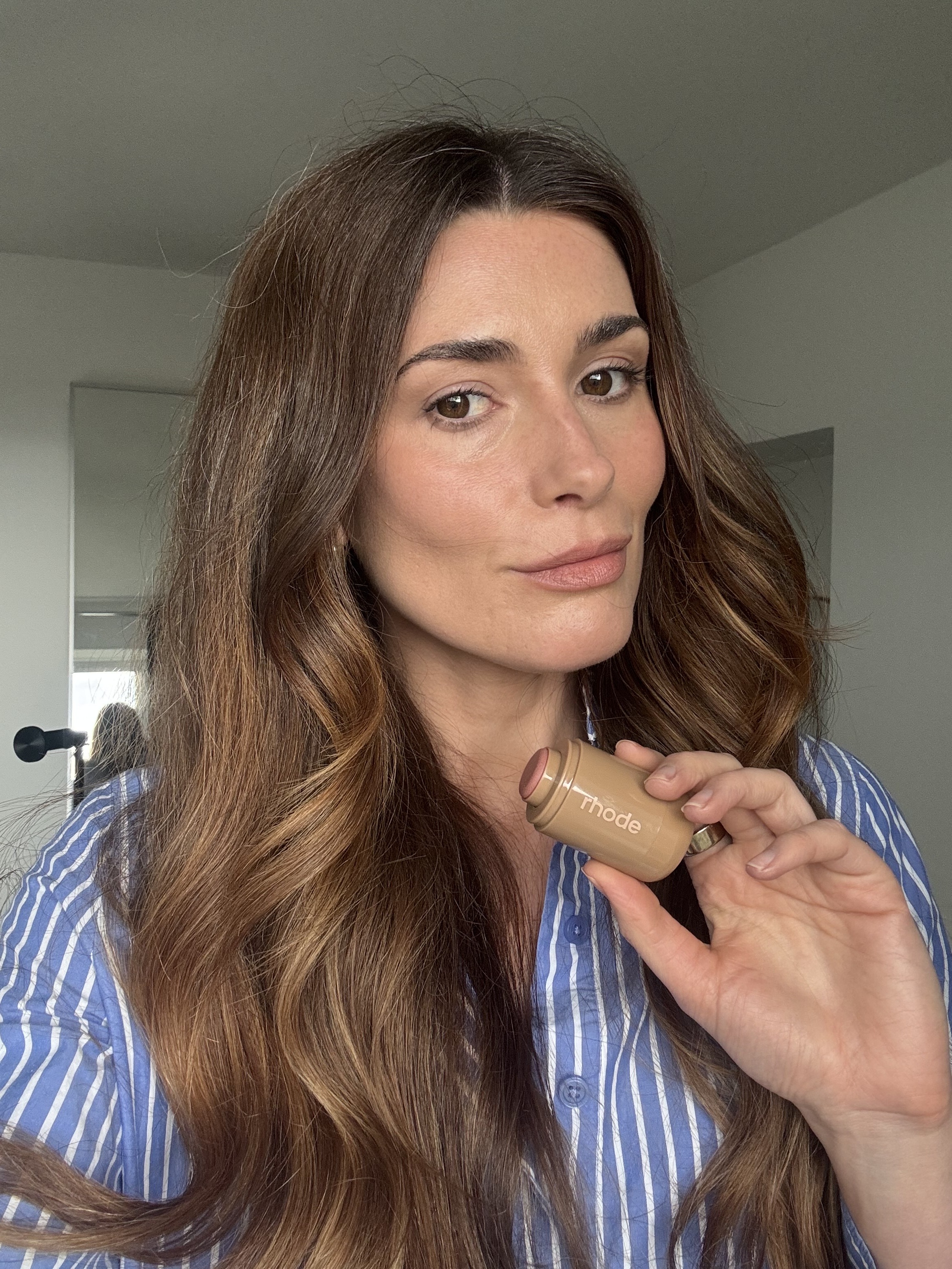 Beauty editor Eleanor Vousden holding the Rhode Pocket Blush in Tan Line