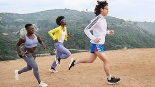 2 men and 1 woman running on a hill in adidas attire