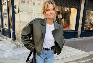 A French woman wearing a leather jacket and jeans.