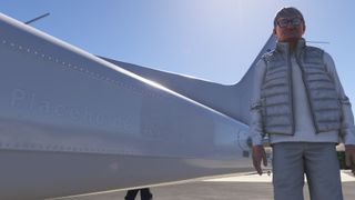 Man standing next to a white plane that reads "Placeholder Airways"