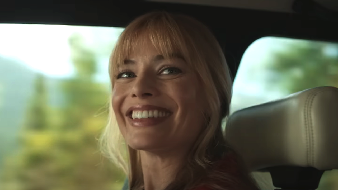 Margot Robbie smiling in passenger seat of car in A Big Bold Beautiful Journey