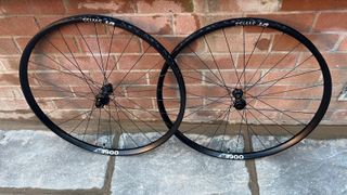 Pair of DT Swiss 1900 wheels against a brick wall